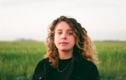 woman in black jacket standing on green grass field during daytime